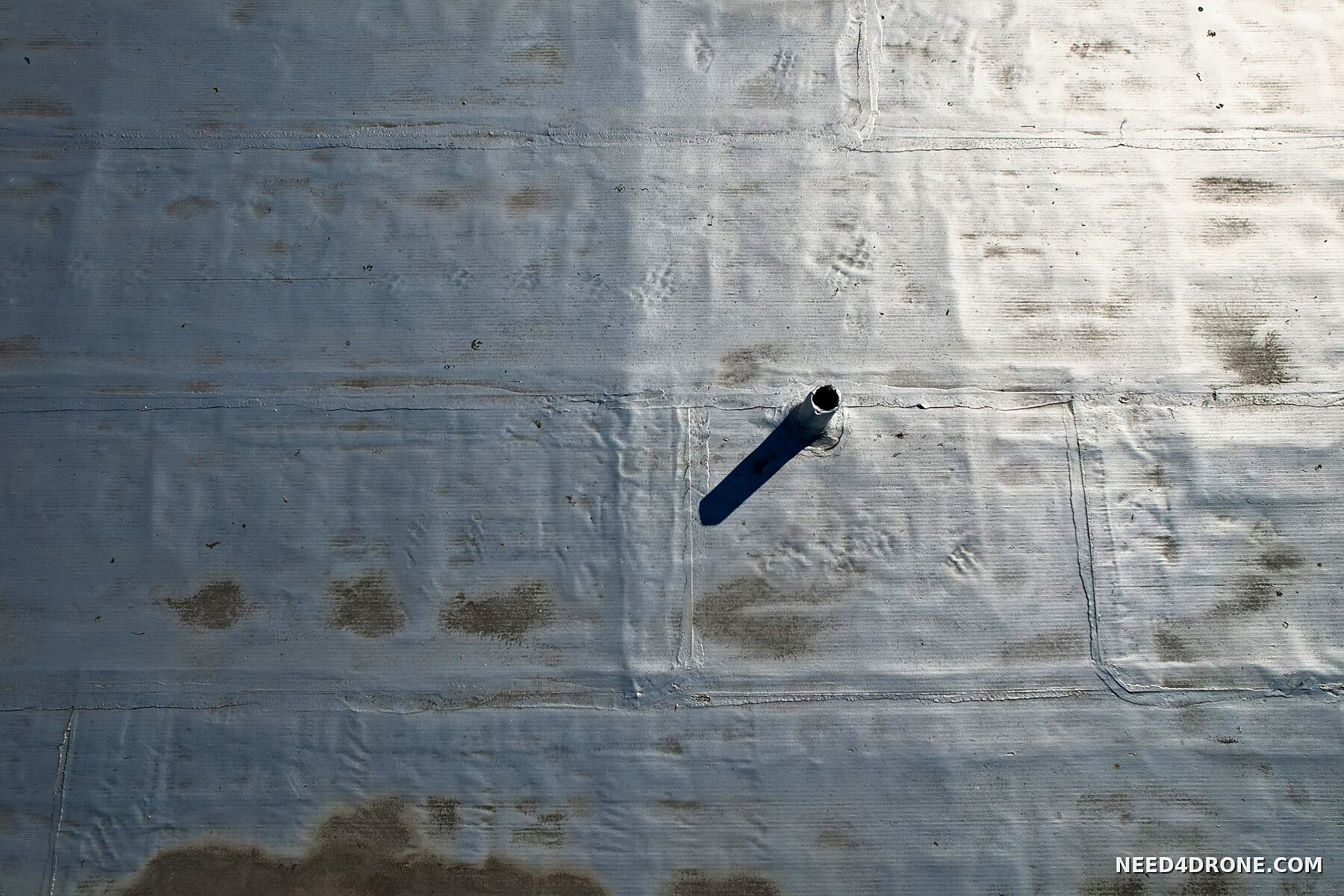 Close-up of roof membrane seams and a vent boot